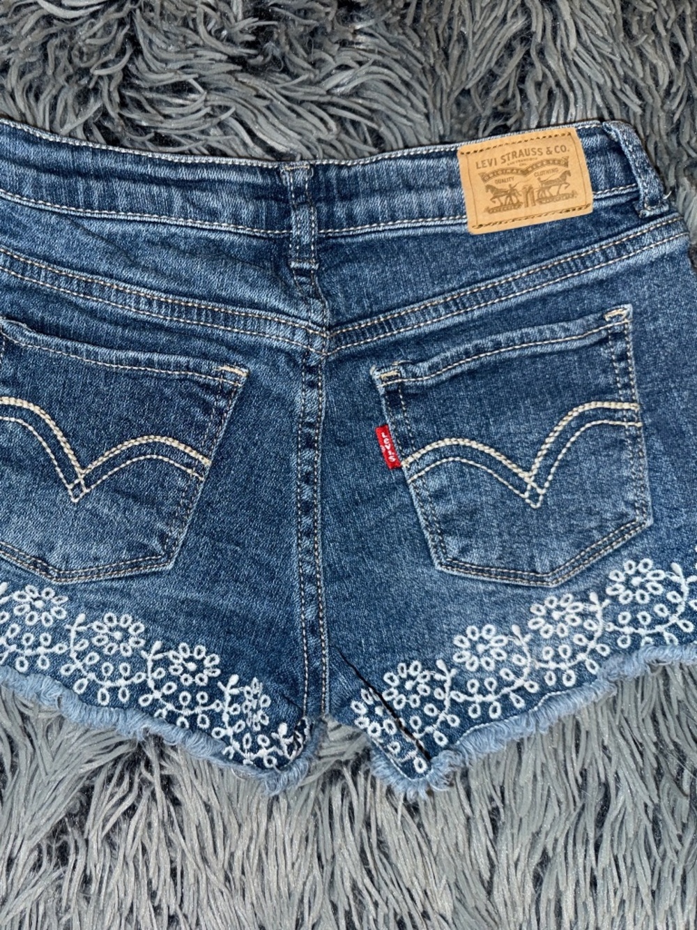 Levi's girl's blue denim shorty shorts, white flower embroidery at hem, sz 12